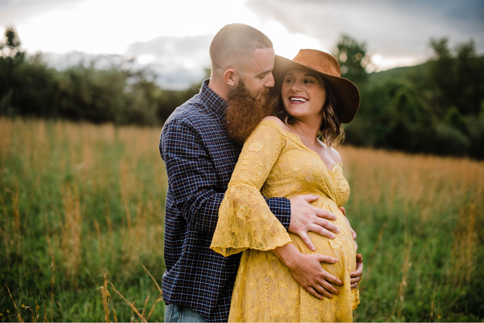 The couple poses with a baby bump