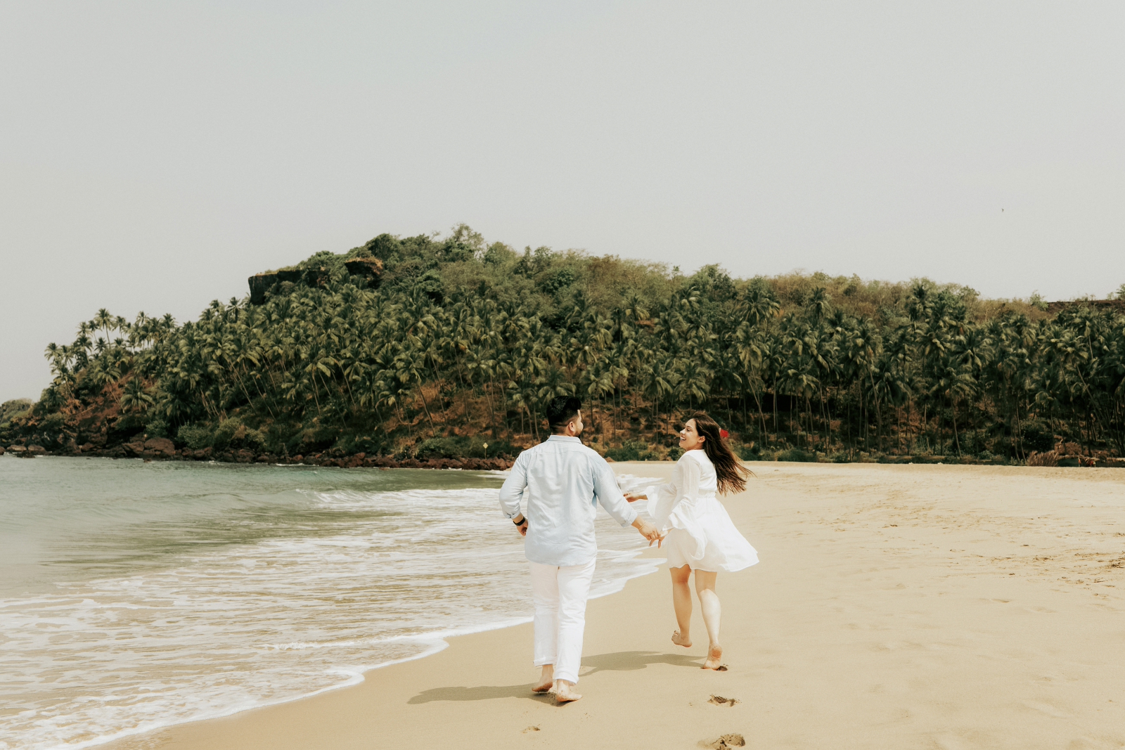 Candid photo of couple on beach during pre wedding shoot