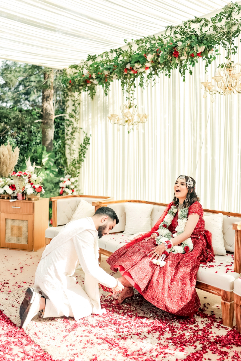 Groom on bridemaids duty | helping the bride tying her shoes caught in cute candid moment