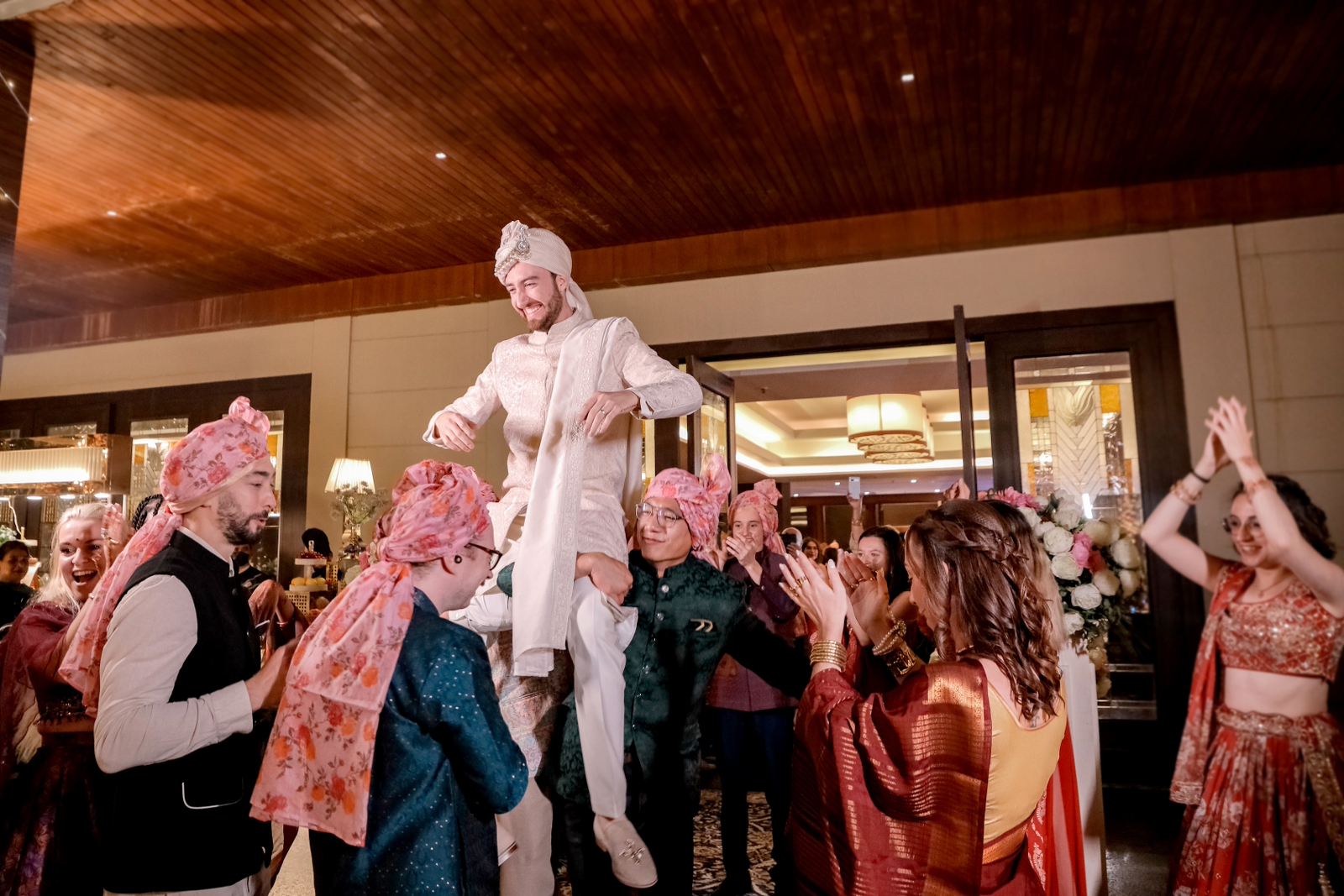 Candid shot of groom during the entry where his friends are hoisting him on shoulders