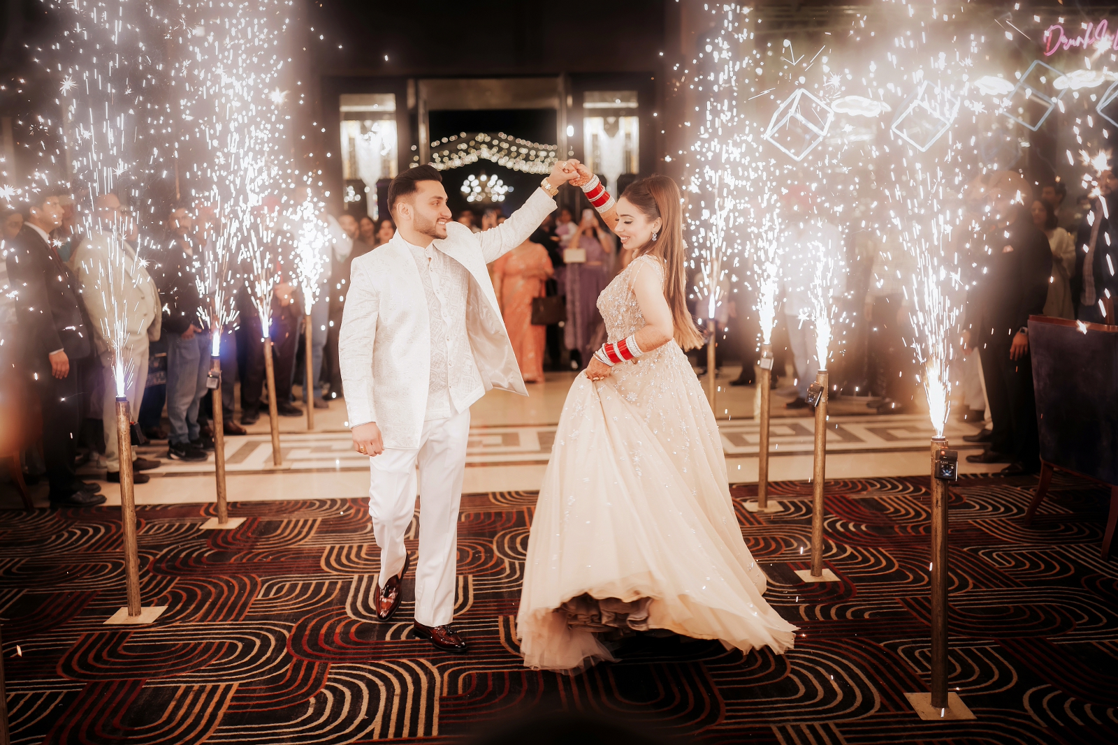 Portrait of bride and groom entering their wedding reception with cold pyros lighting in the surrounding