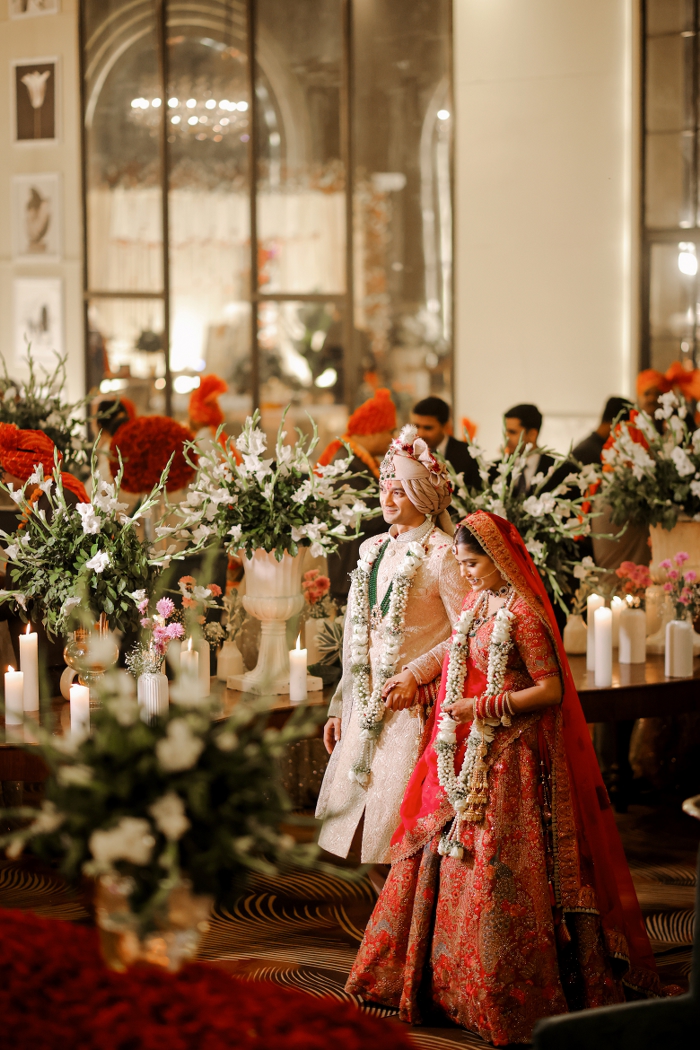 Candid shot of bride and groom entering the venue hand in hand
